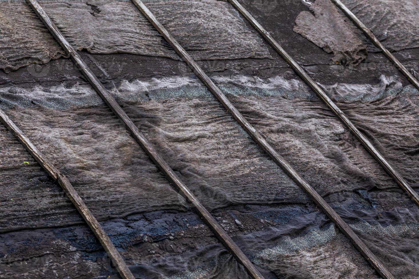 old rotten black ruberoid shed gable roofing close-up with selective focus and blur photo