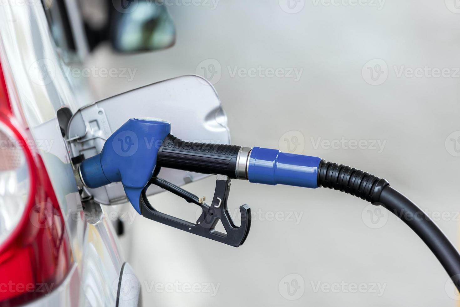 Silver car refuelling at the gas station, the concept of fuel energy photo