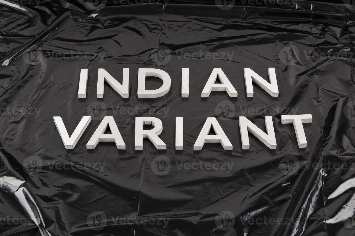 words indian variant laid with silver metal letters on crumpled black plastic bag background in slanted perspective photo