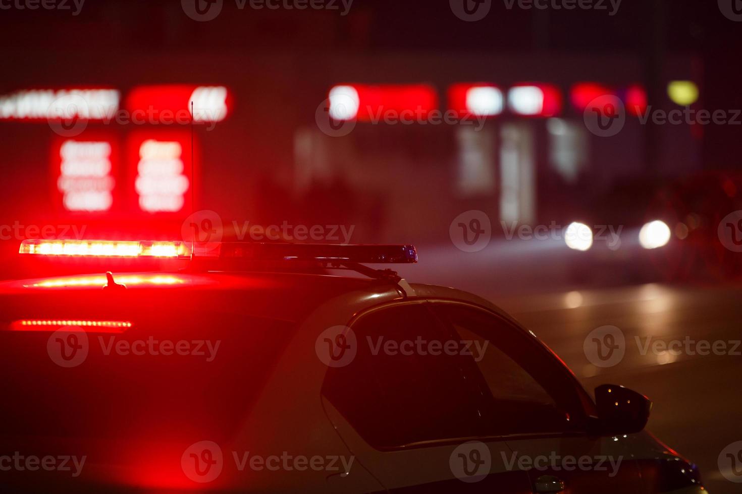 red police car light at night in city with selective focus and bokeh on black background photo