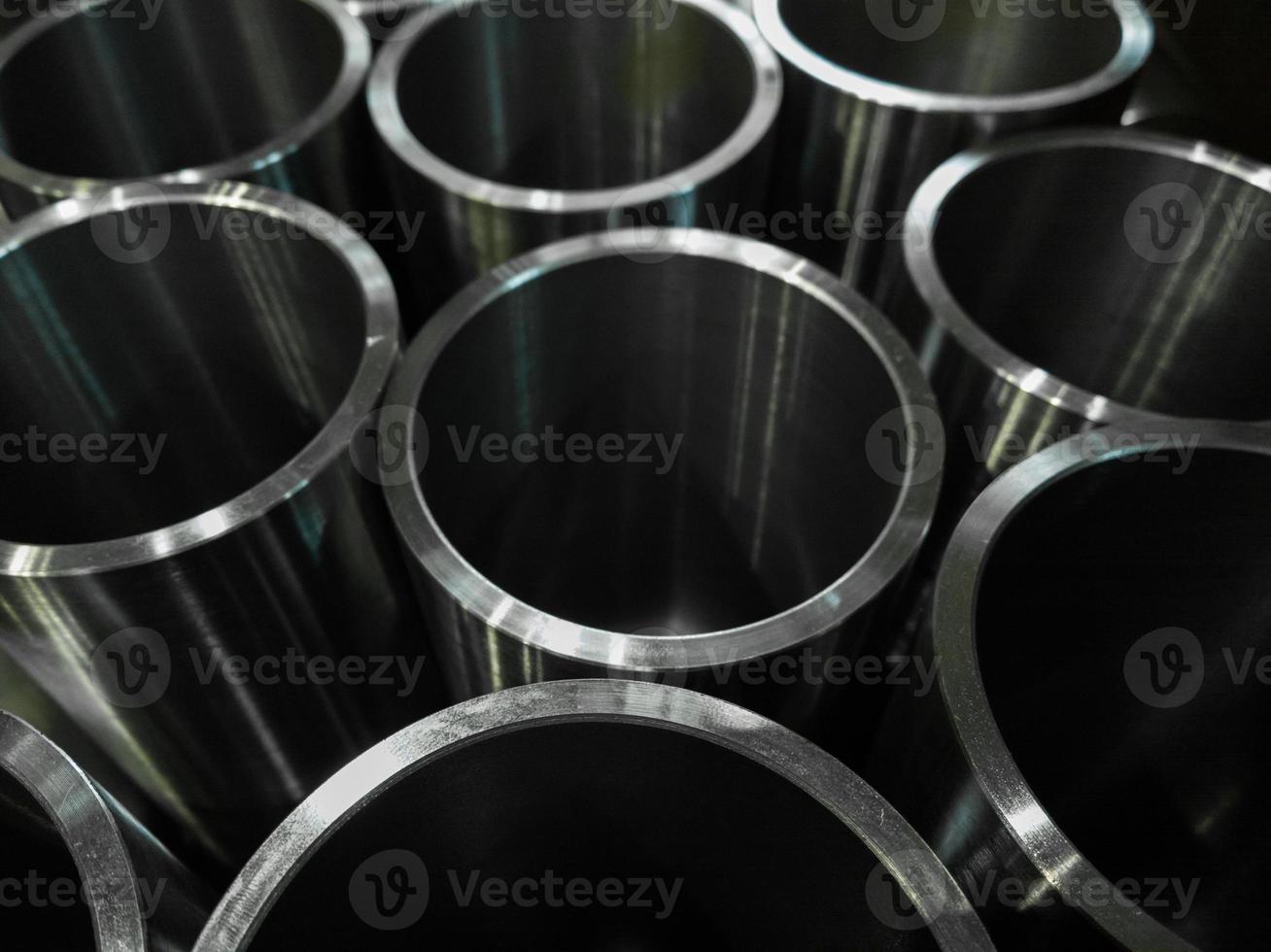 dark industrial background with cnc machined shiny steel pipes - selective focus and lens blur tech photo