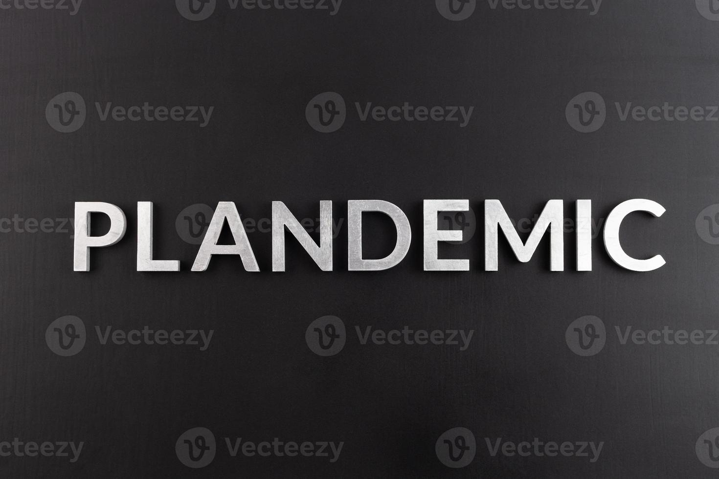 the word plandemic laid with silver letters on flat black background in directly above composition at center of picture photo