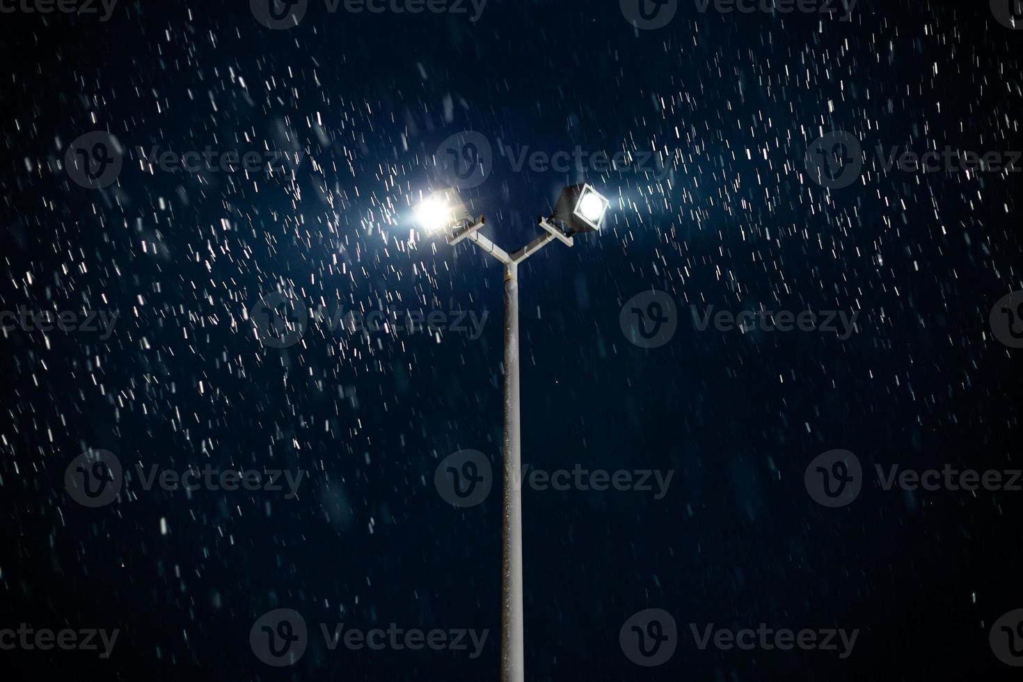 modern double light spot on lamp post at winter night snowfall photo
