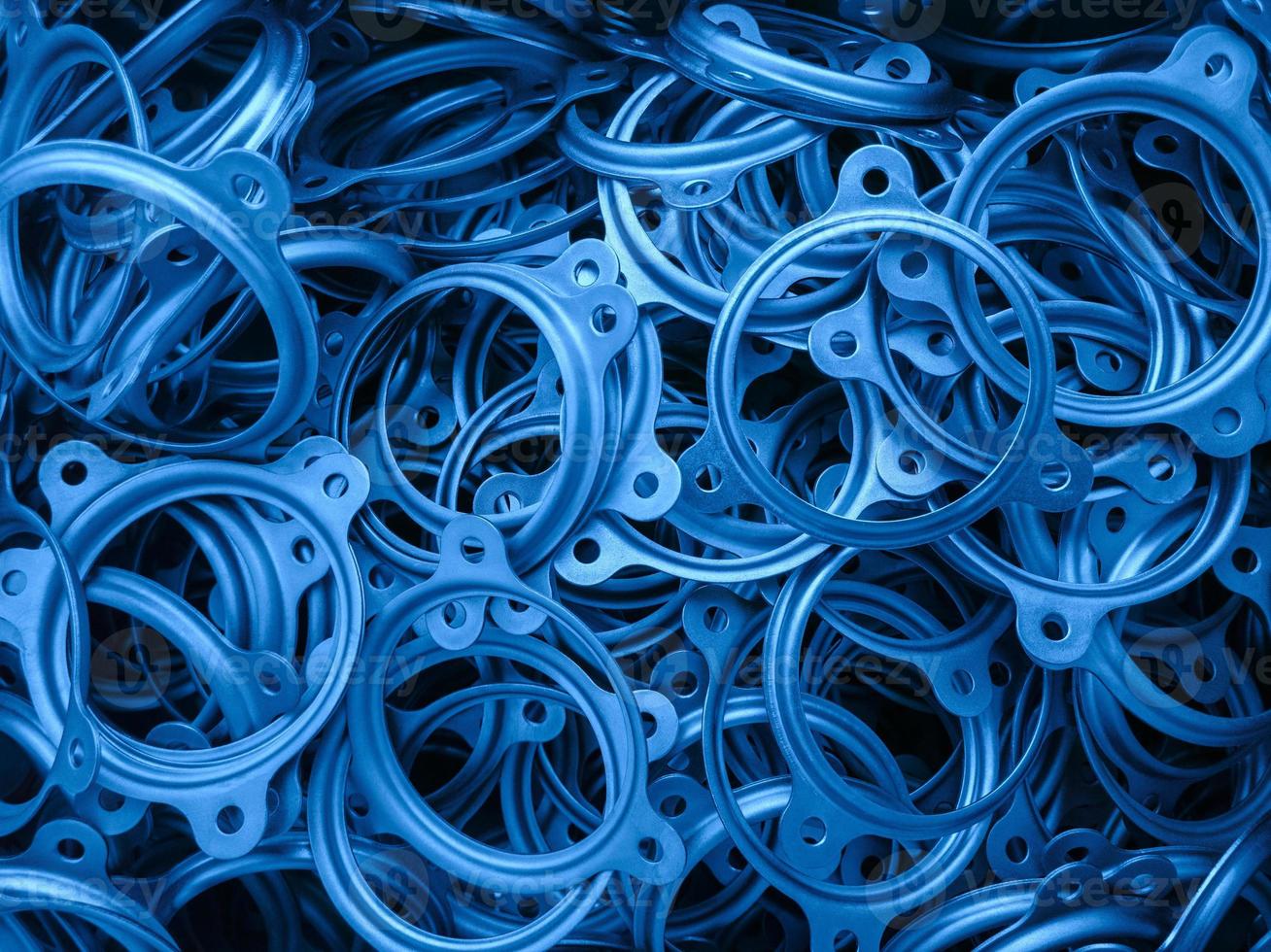 un fondo abstracto de piezas de anillo de brida estampadas de metal recubierto de color azul clásico foto