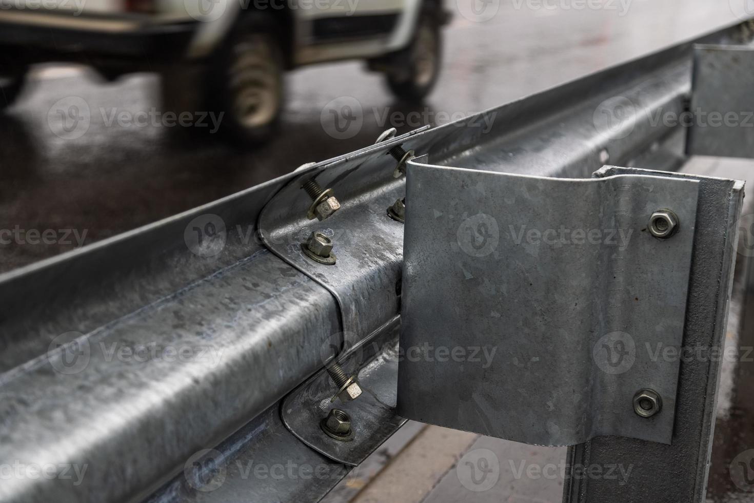 underscrewed nuts and bolts in highway road railing photo