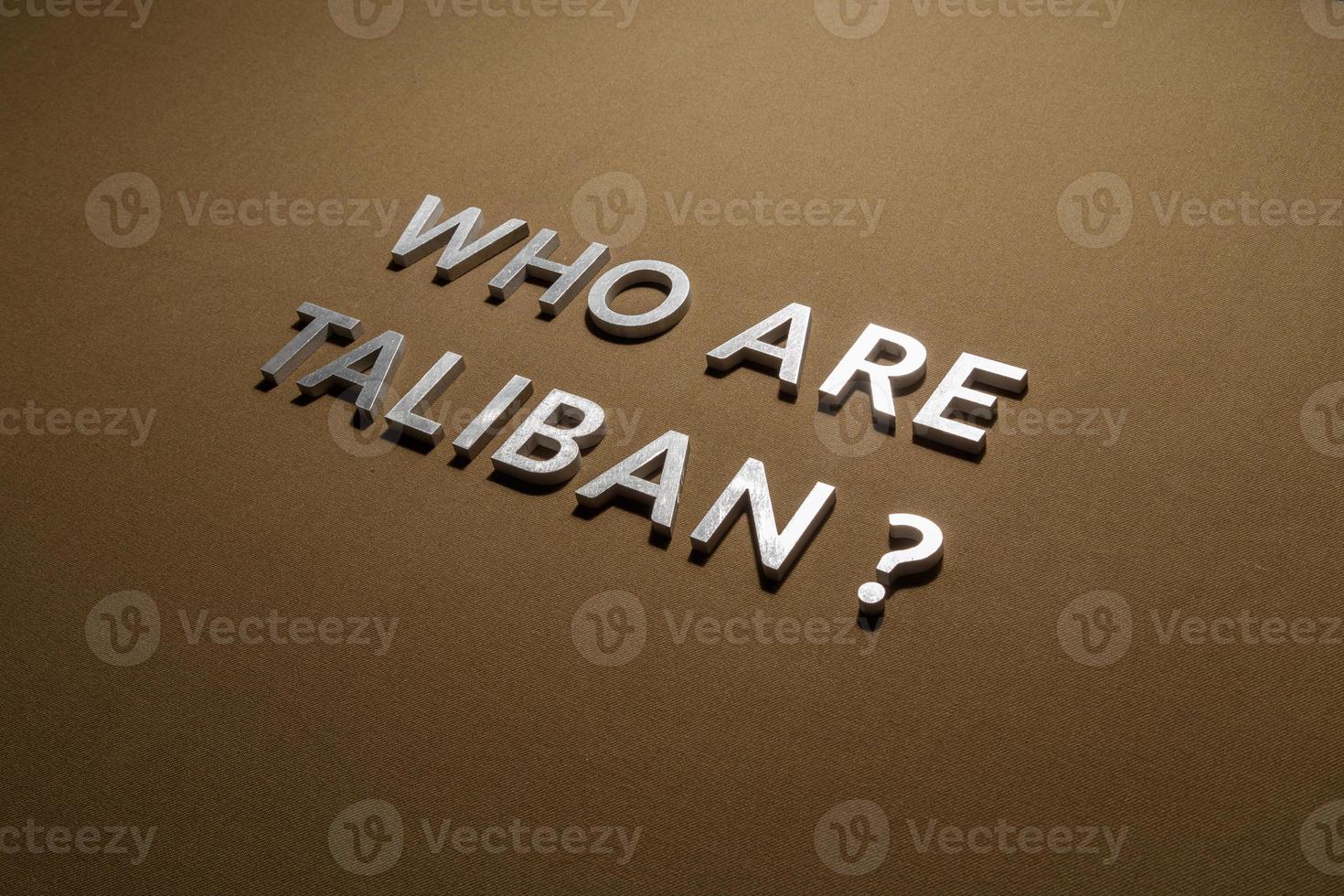 the question who are taliban laid with silver metal letters on rough tan khaki canvas fabric photo
