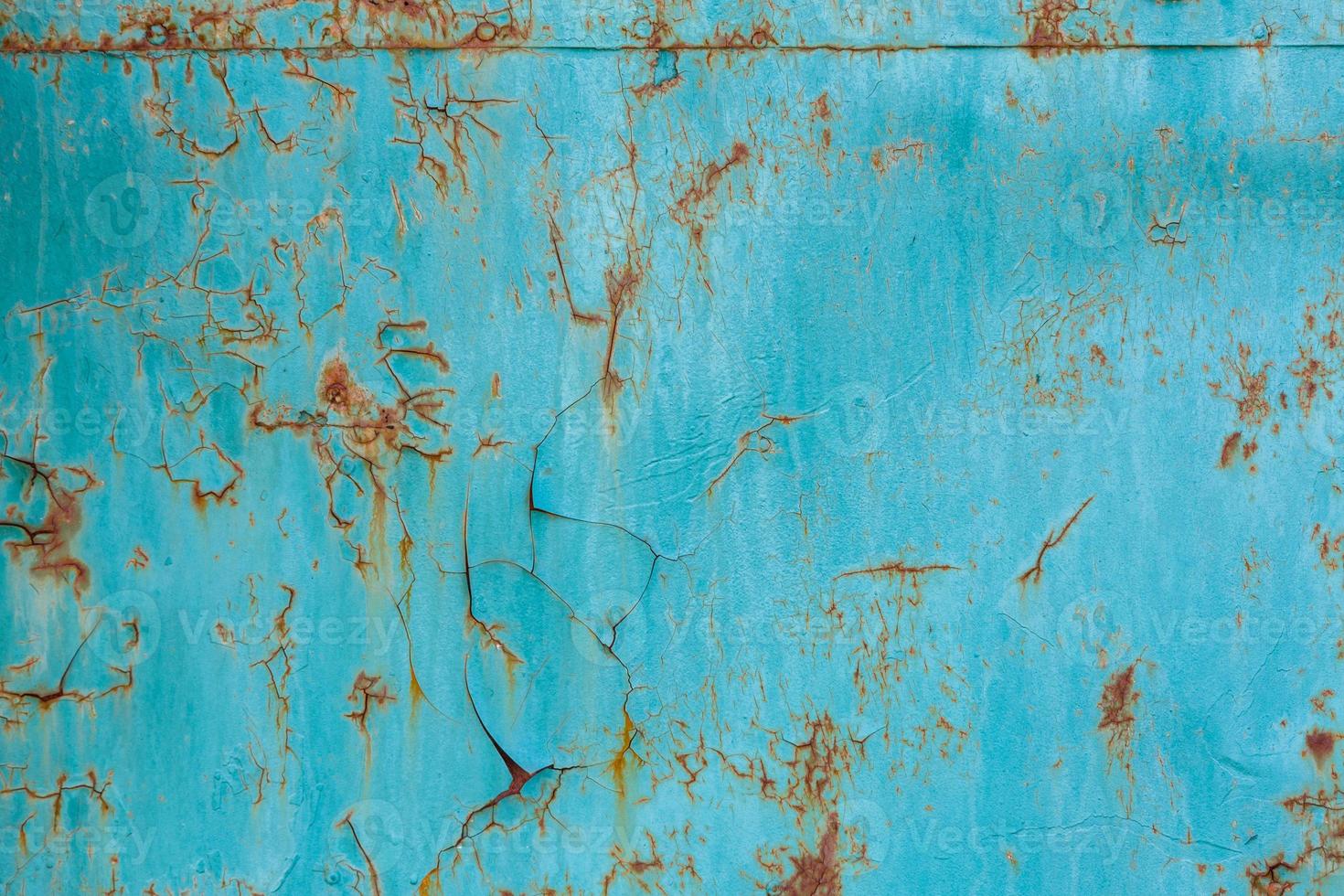 turquoise painted flat steel sheet with cracks and rust stains photo