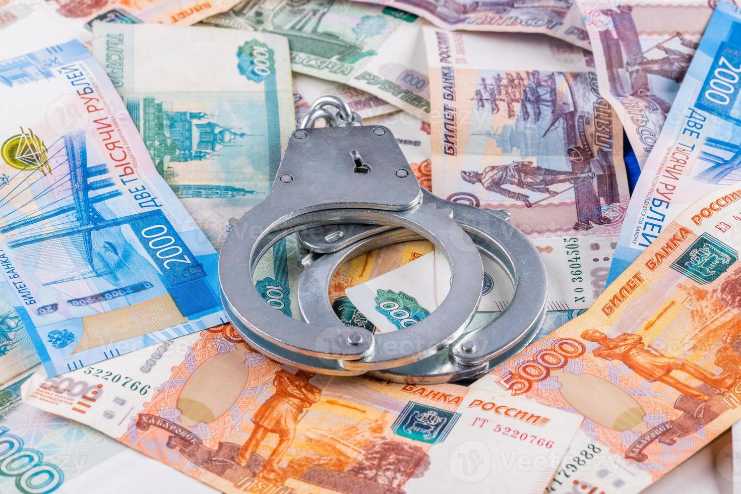 silver colored handcuffs on russian paper rubles currency background photo