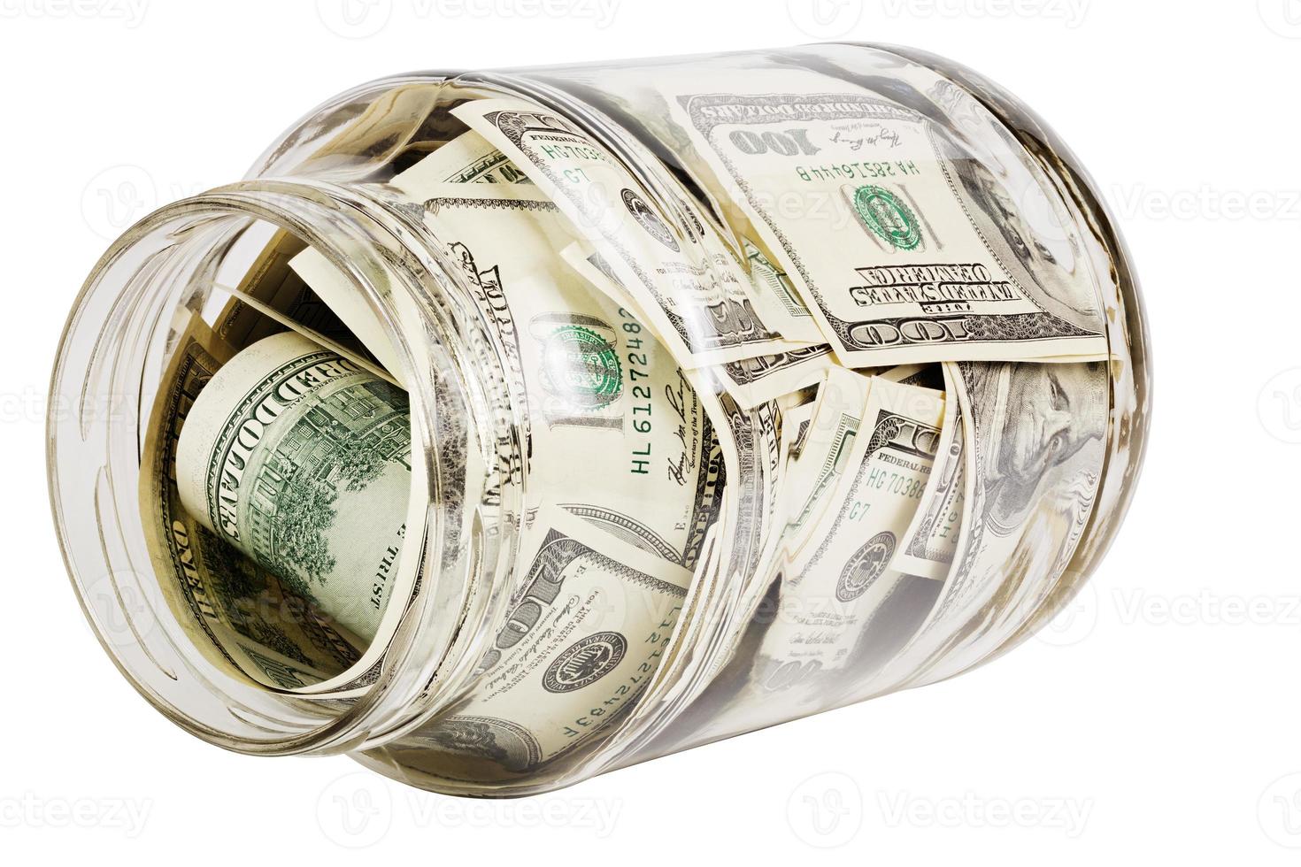 glass jar full of hundred us dollar banknotes laying on side - isolated on white photo