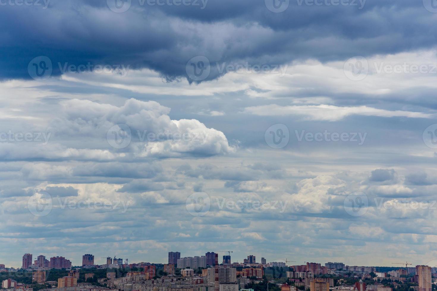 russian summer daylight cityscape with large cumulus clouds and tiny horizon line of the panel condominium houses photo