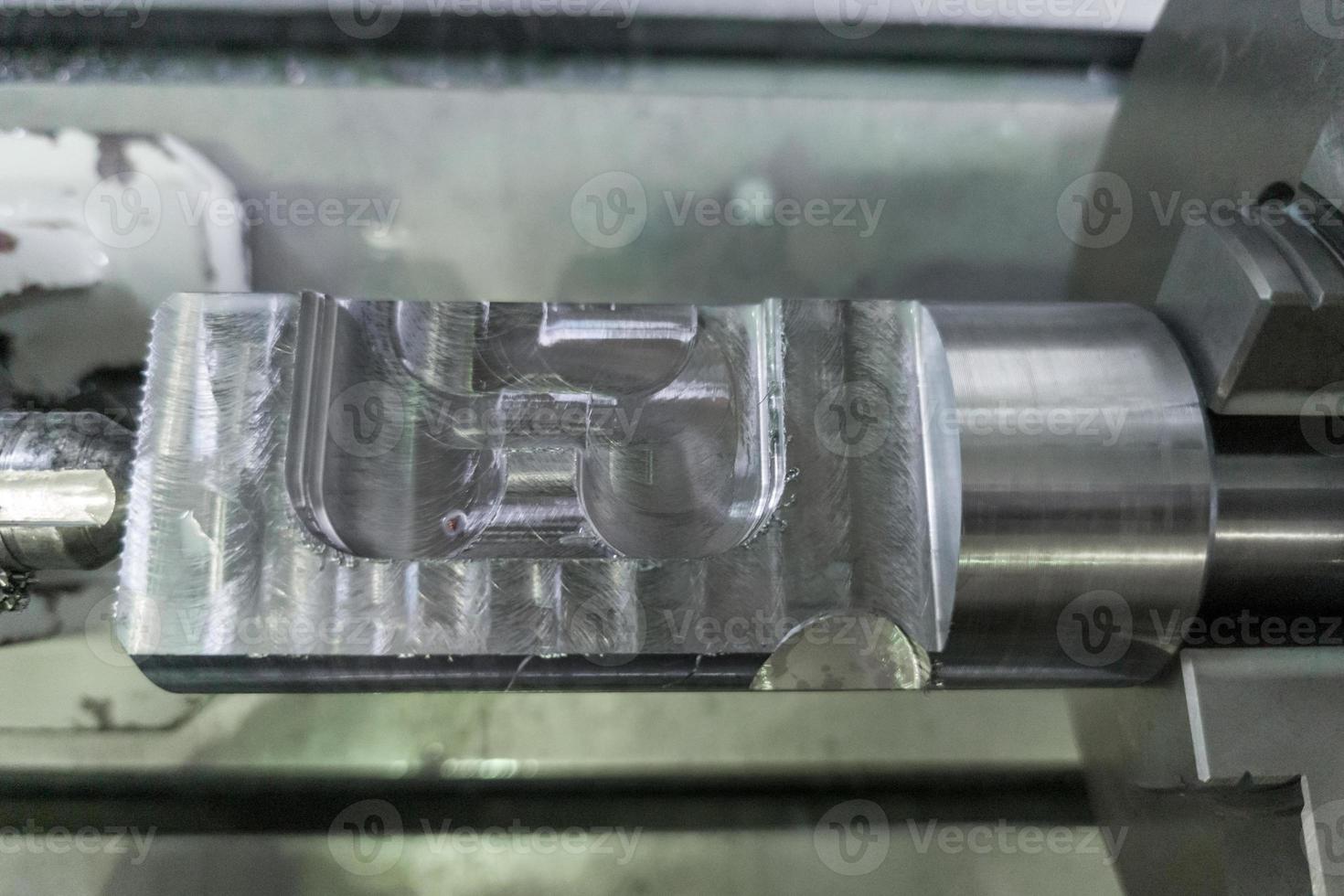 cylindrical workpiece clamped in 4-th axis of cnc milling machine after rough end milling operation photo