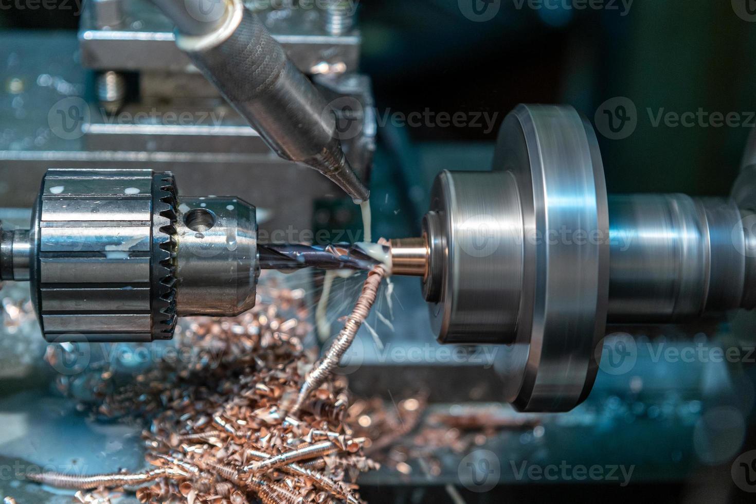 a process of brass drilling in lathe with liquid coolant photo