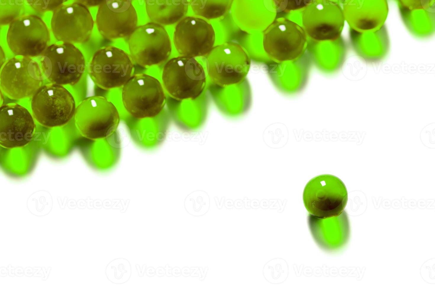 Cápsulas de bola esférica verde OVNI con enfoque selectivo aislado sobre fondo blanco. foto