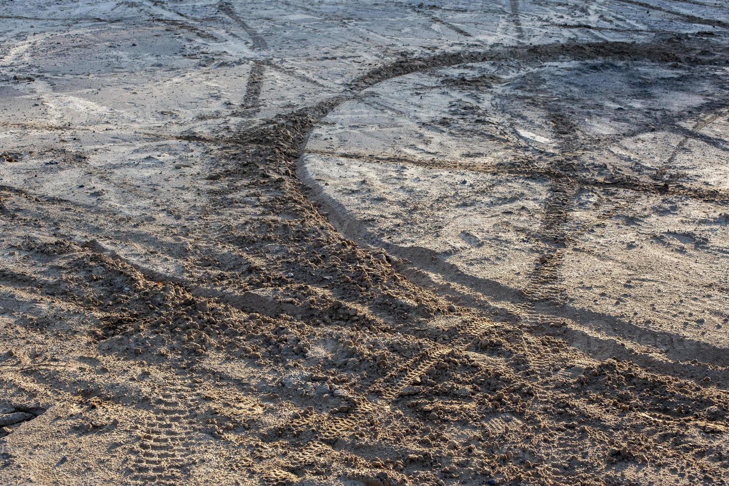 dry sand and mud ground with many dirt bike tracks at daylight photo