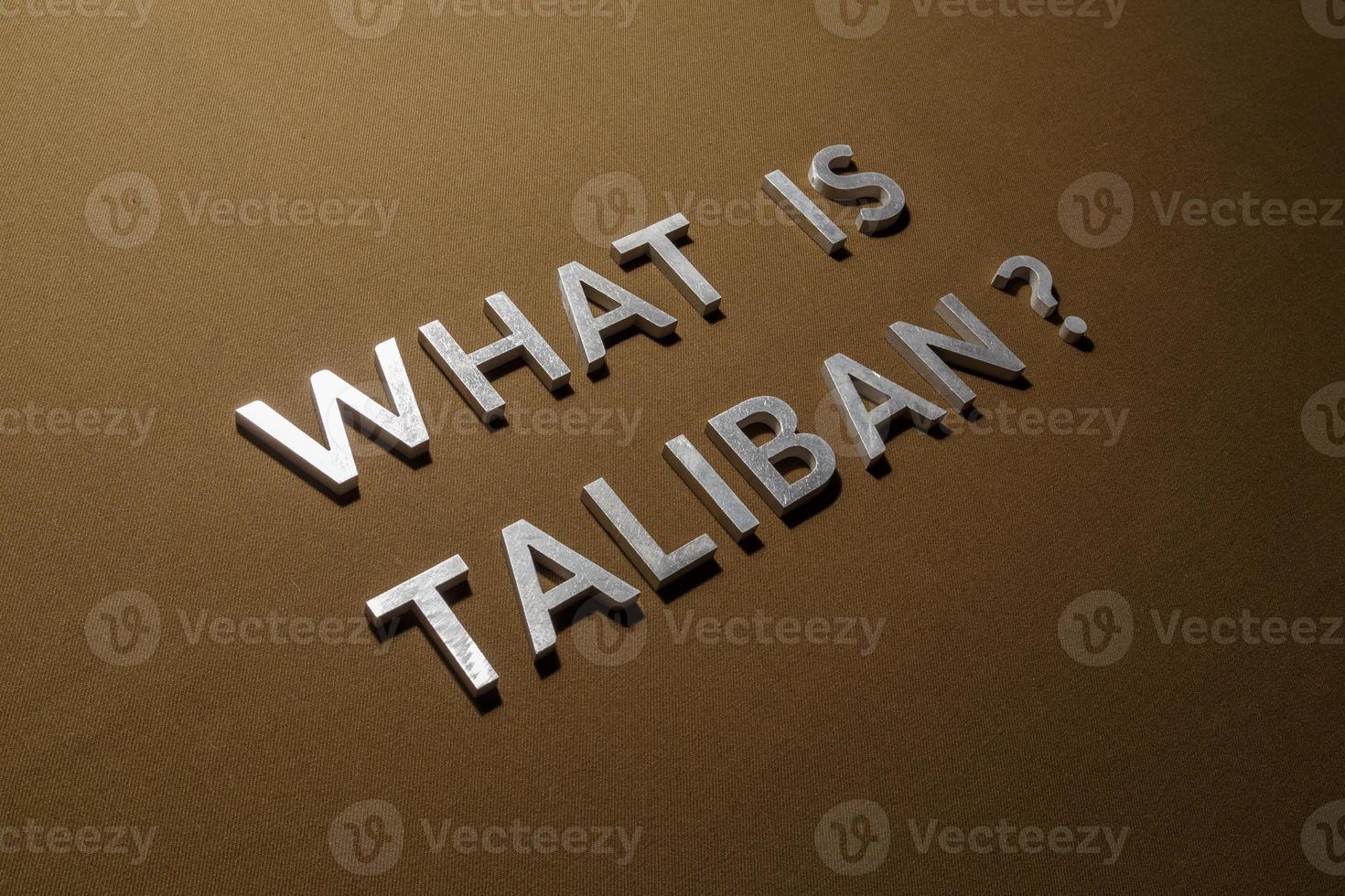 the question what is taliban laid with silver metal letters on rough tan khaki canvas fabric photo