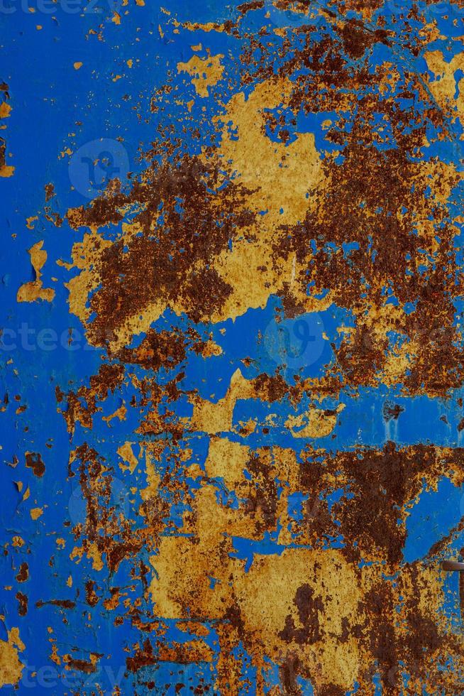flat texture of rusted steel sheet with two peeled off layers of paint - yellow and blue photo
