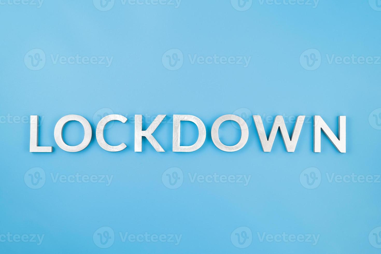 the word lockdown laid with brushed aluminium metal letters on blue background photo