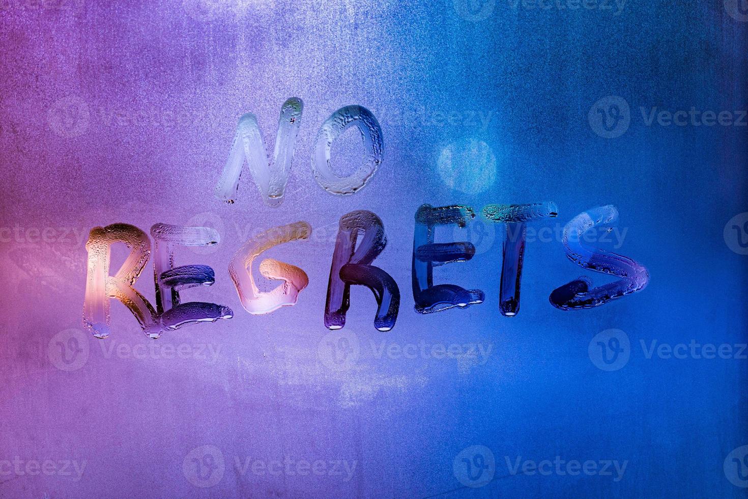 words no regrets hand written on purple-blue night foggy window glass photo