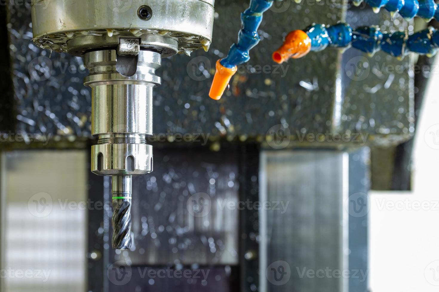 wet carbide mill and collet chuck in vertical cnc milling machine with plastic hose system for coolants and air photo