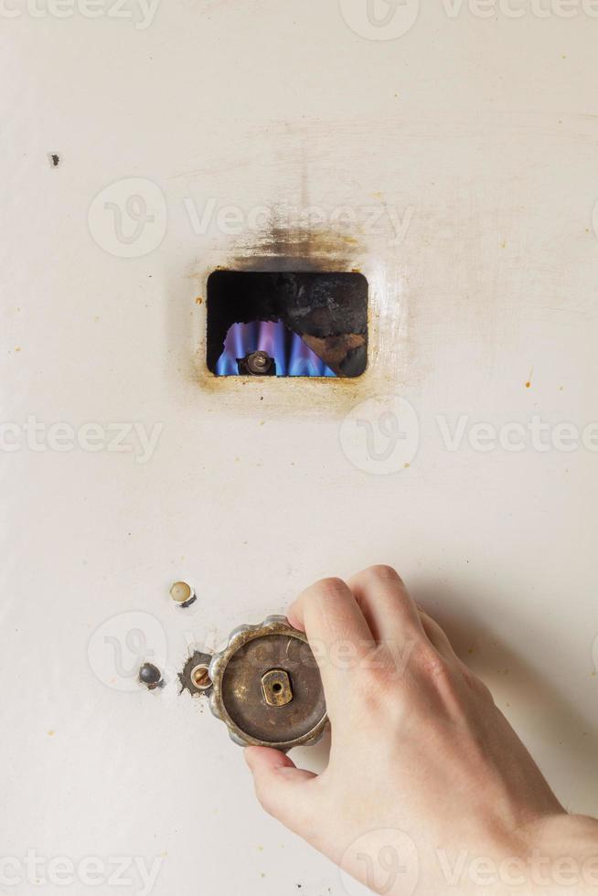 Hand adjusting old russian gas water heater photo
