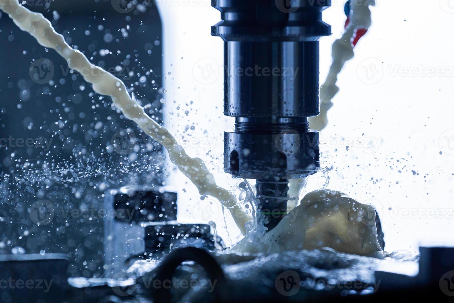 a process of vertical cnc steel milling with external water coolant streams, splashes and a lot of metal chips, high contrast, shallow depth of field. photo