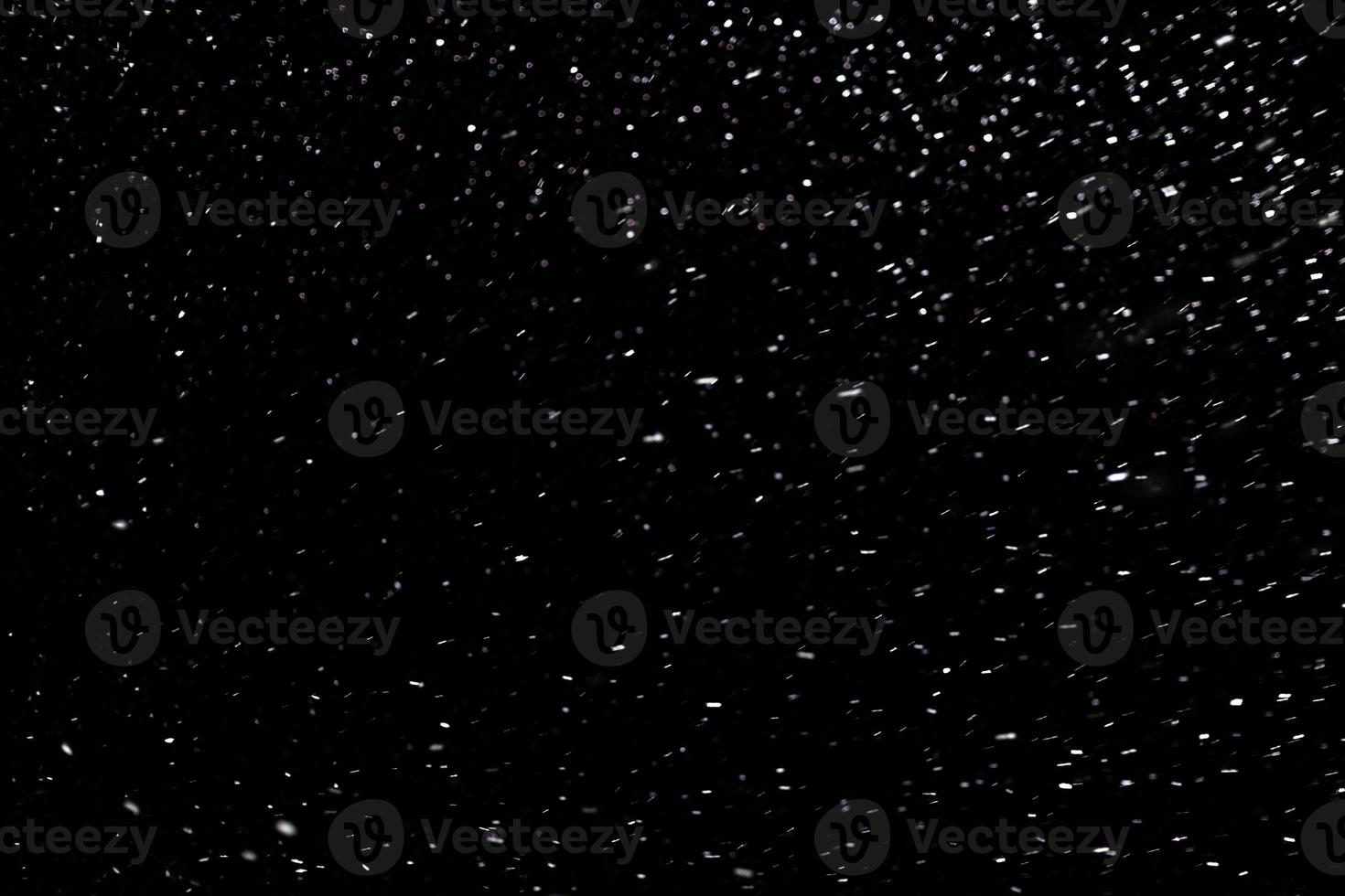 natural snow on black night background with selective focus photo