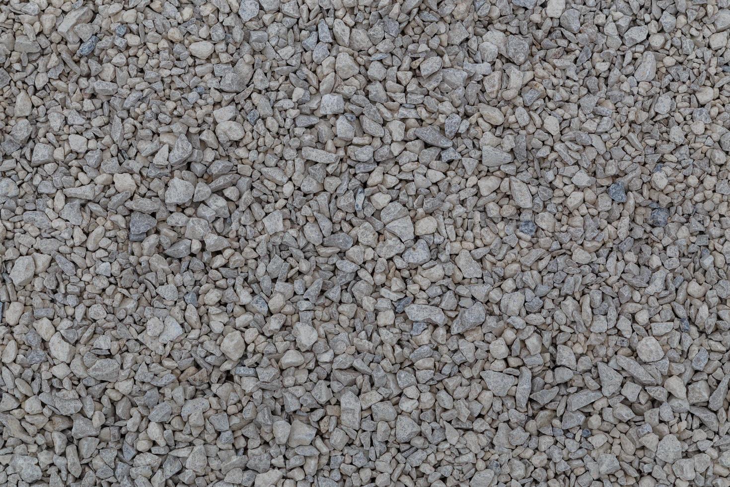 Dry white limestone ballast flat full frame background. Small gray dusty broken macadam stones texture. photo
