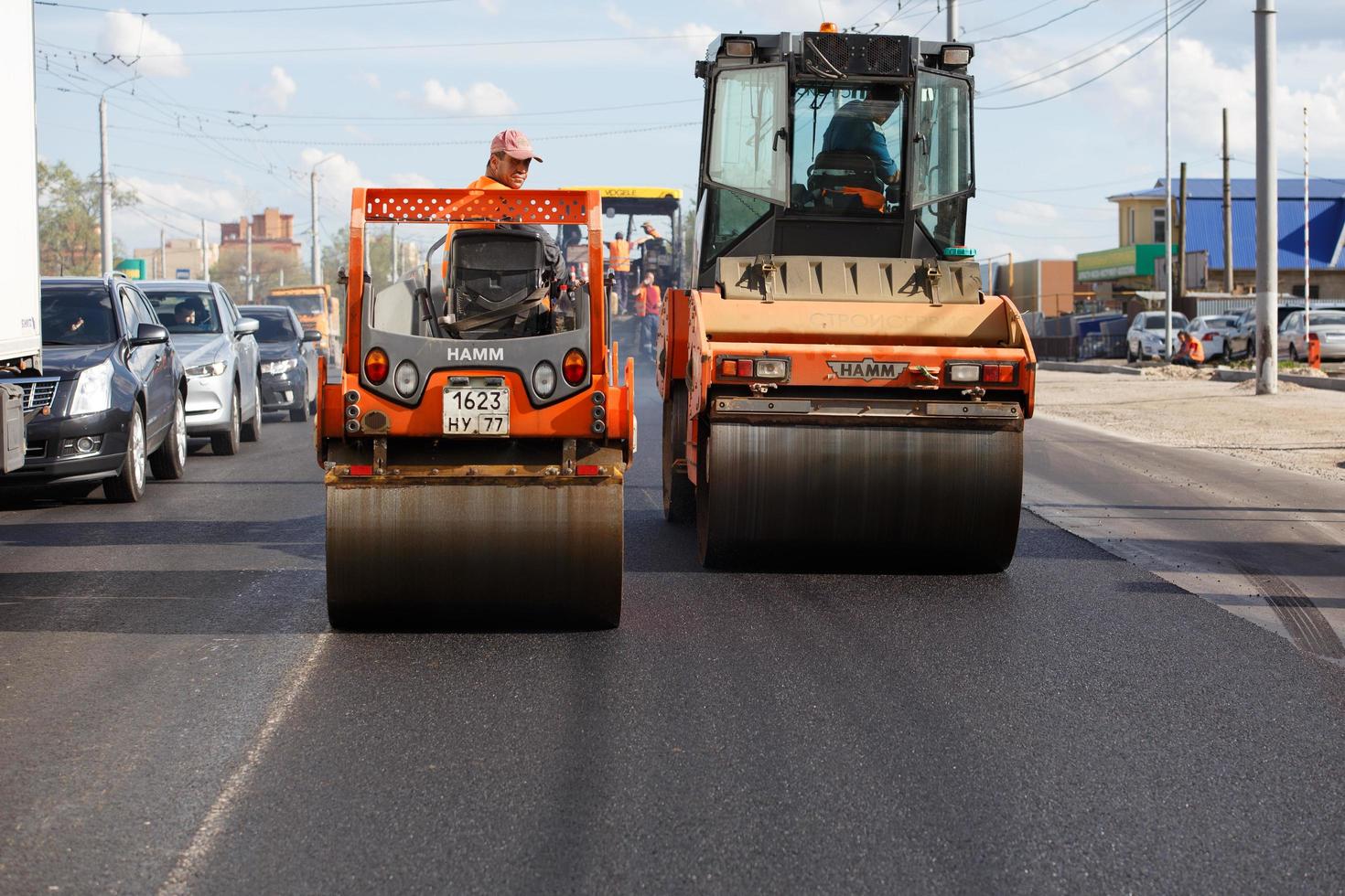 tula, rusia 16 de mayo de 2021 proceso de asfaltado, dos rodillos de vapor de carretera durante los trabajos de construcción de carreteras, en el día de verano foto