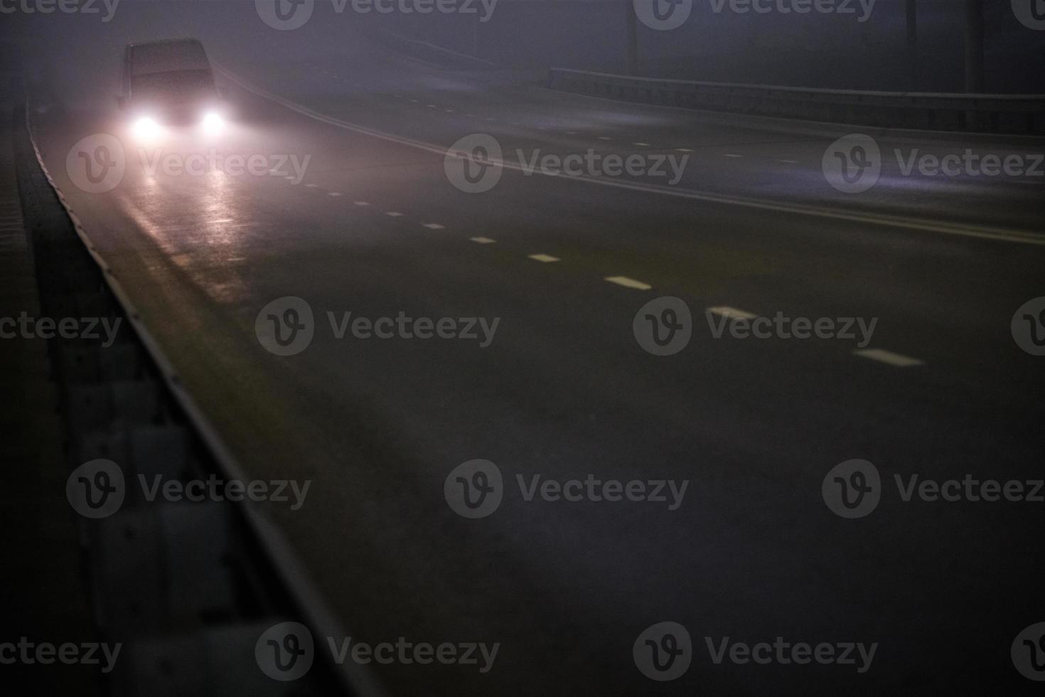 alone minivan moving on empty night foggy road photo