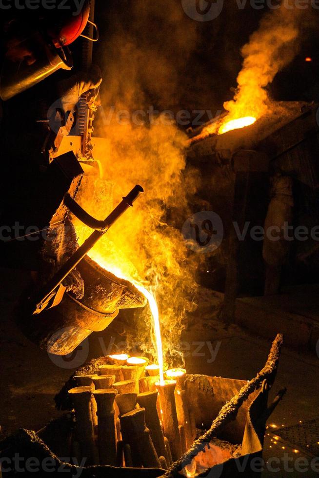 Industrial lost wax casting. The process of pouring for filling out ceramic shells with molten steel. photo