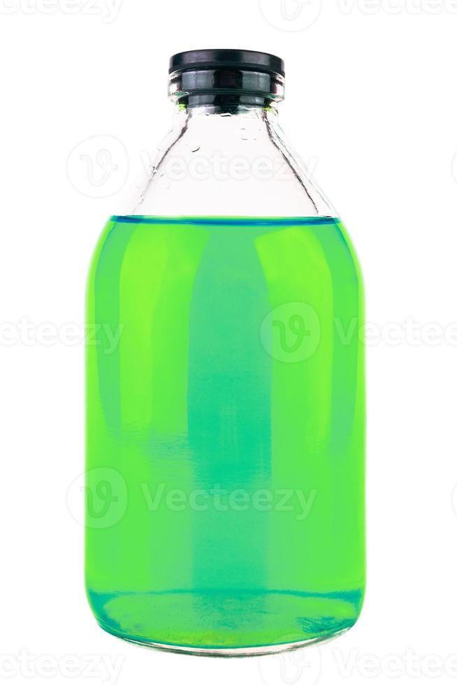 closed old style glass medical or chemical bottle with green transparent liquid isolated on white background photo