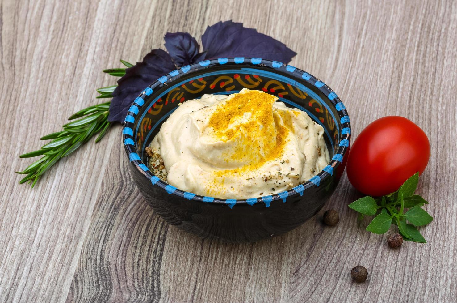 Hummus in a bowl on wooden background photo