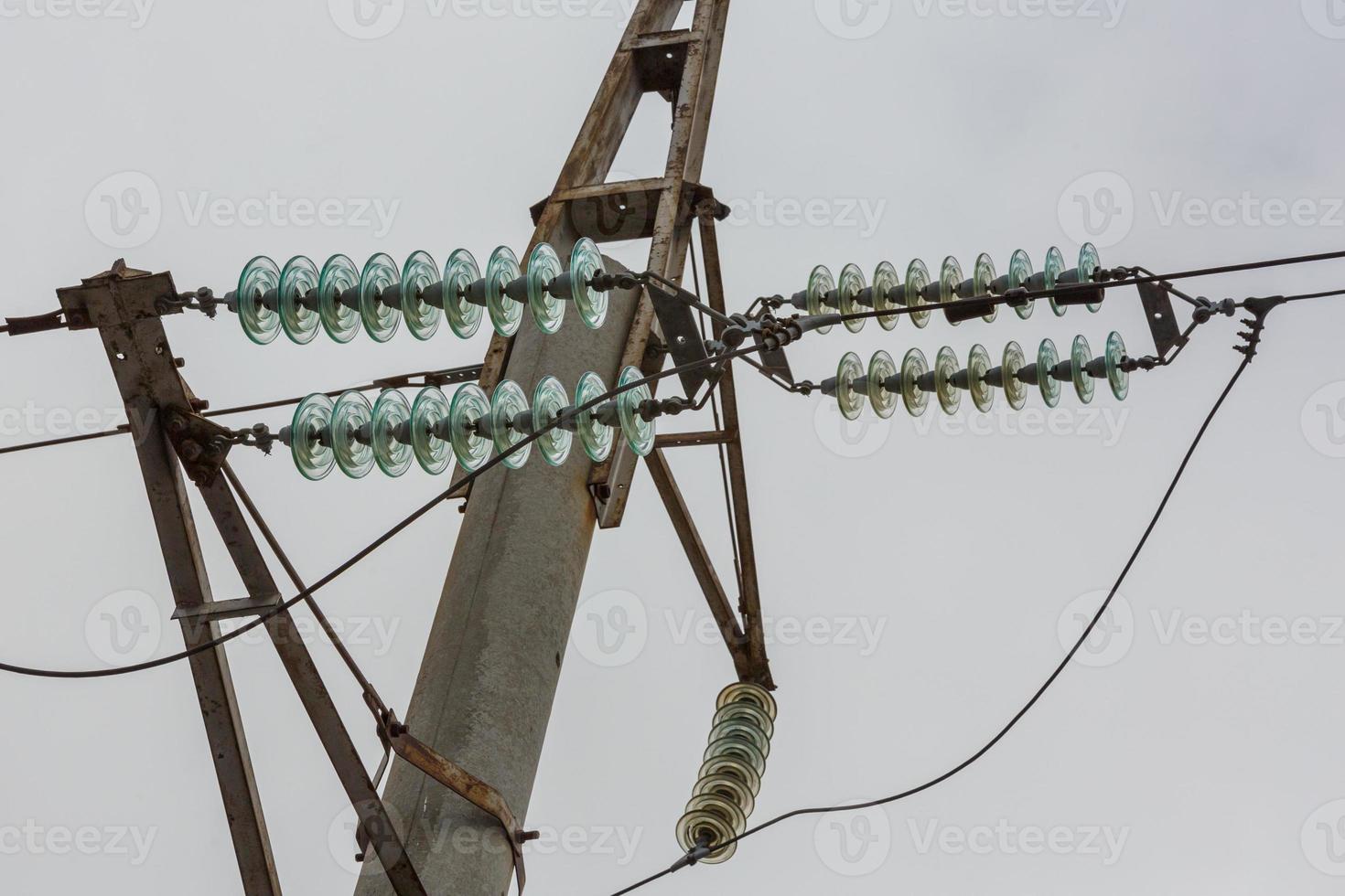 High voltage power line pole with glass electrical insulators on wires photo