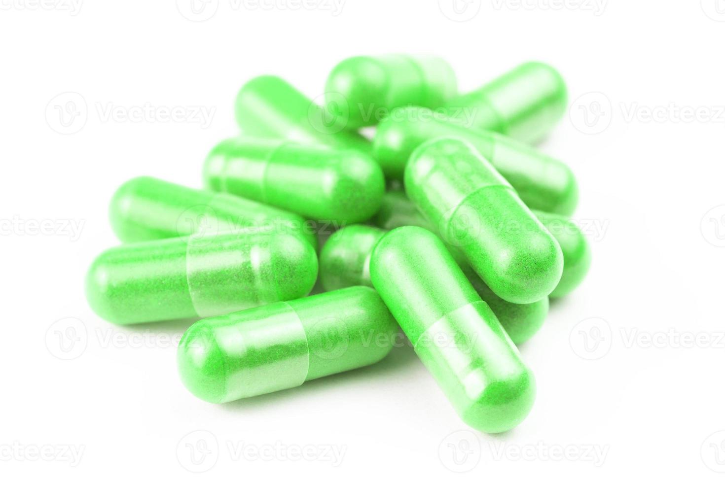 pile of ufo green organic capsules isolated on white background closeup with selective focus photo