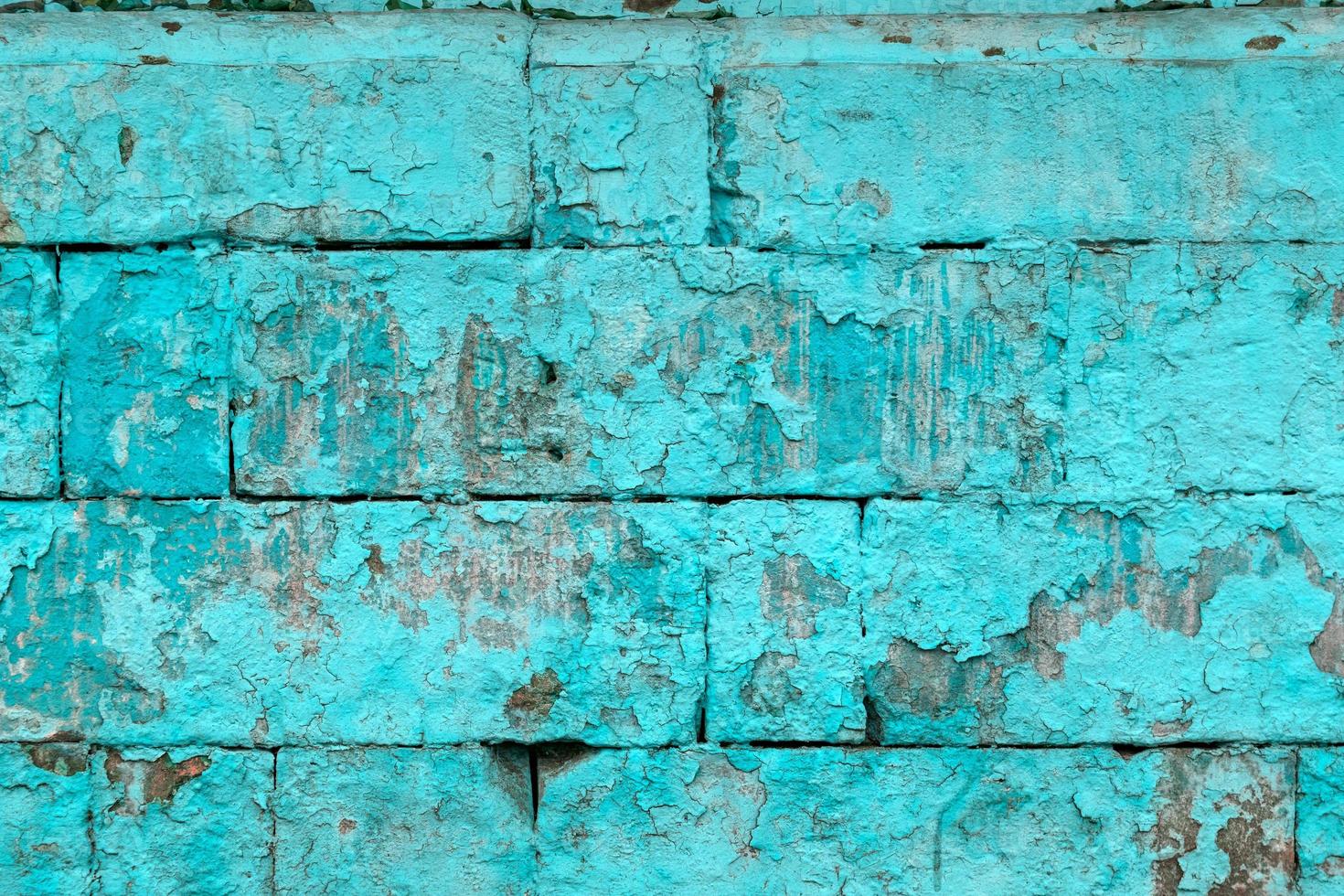 peeled off old turquoise paint on flat rough brick wall surface - full frame background and texture photo