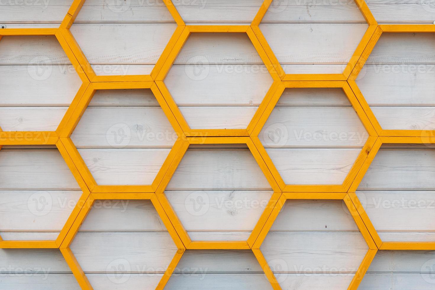 yellow honeycomb pattern wooden shelf on white painted wooden plank wall photo