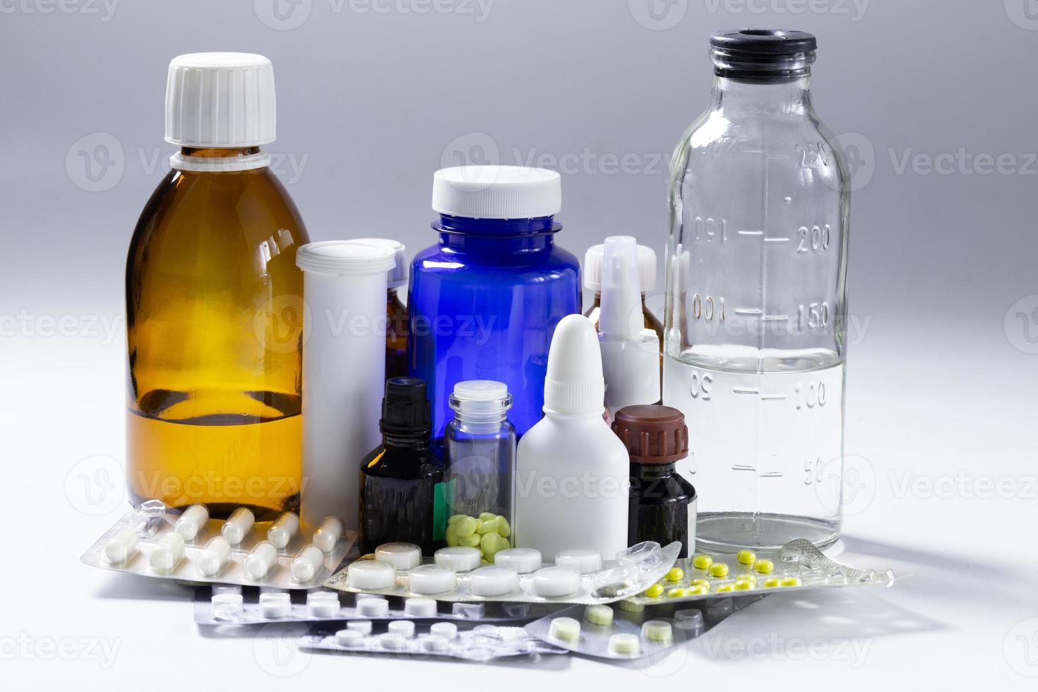 bunch of used medial bottles and tablets on gray background photo