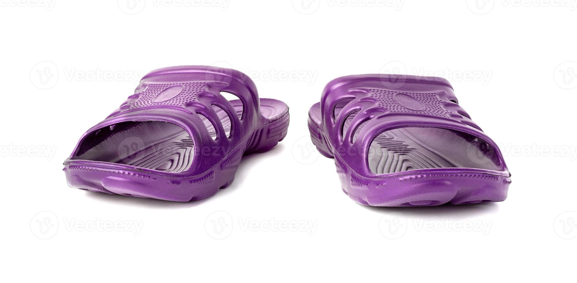 pair of cheap durable purple rubber slippers isolated on white background. photo