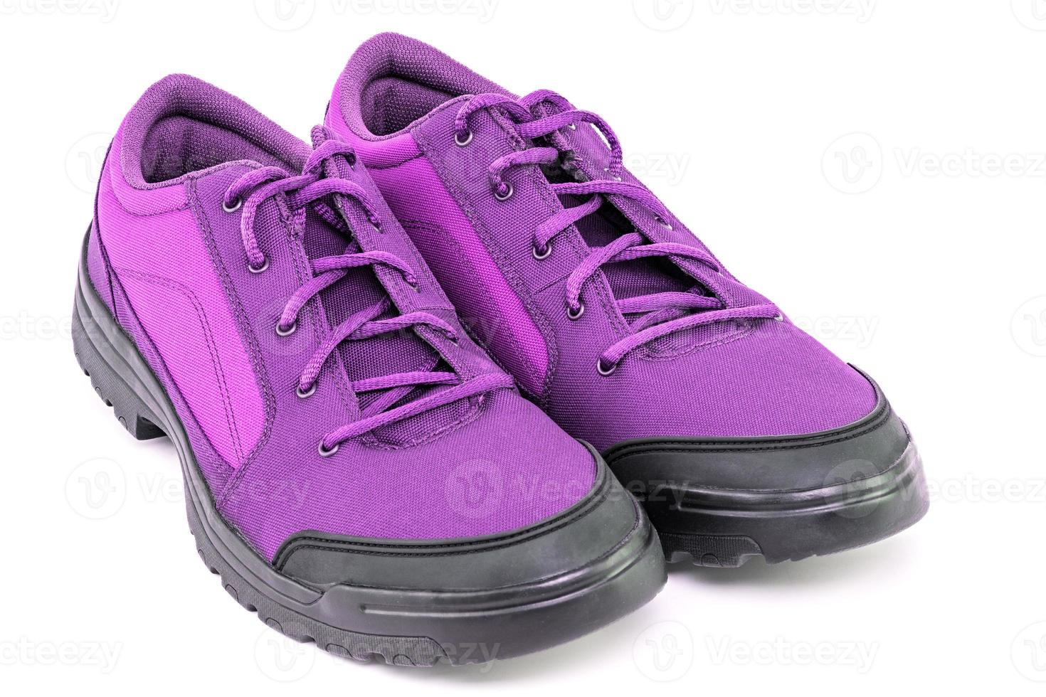 a pair of simple cheap purple hiking shoes isolated on white background - perspective close-up view photo