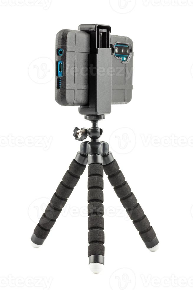 black cellphone in rugged rubber protective cover on small flexible tripod isolated on white photo