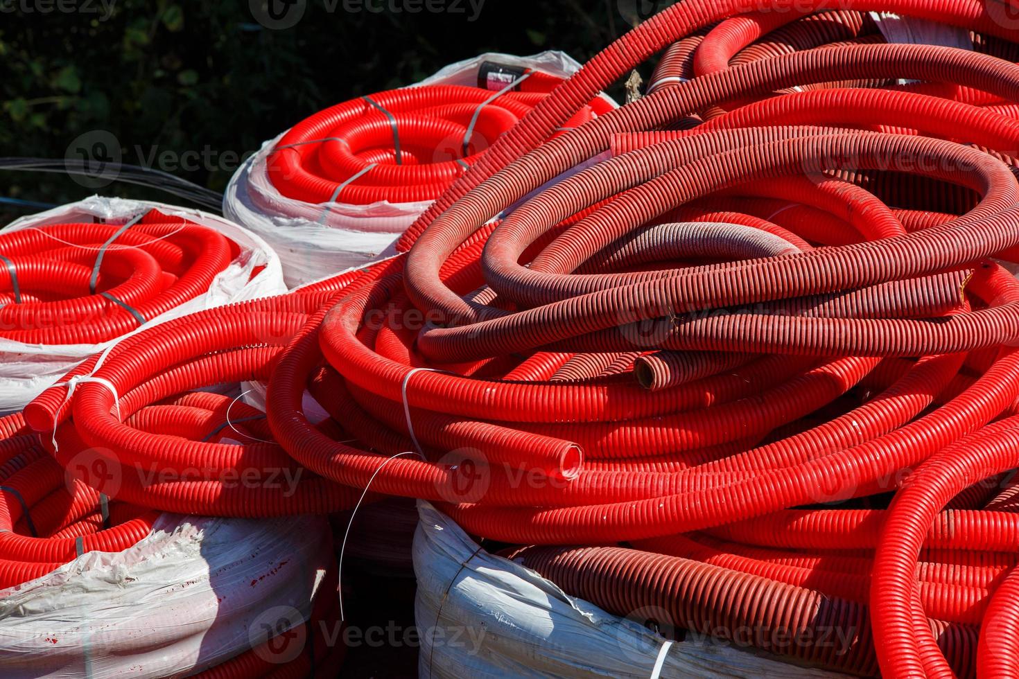 red corrugated PVC pipes for cable lay on the construction site photo