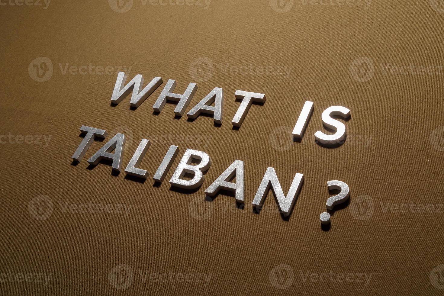 the question what is taliban laid with silver metal letters on rough tan khaki canvas fabric photo