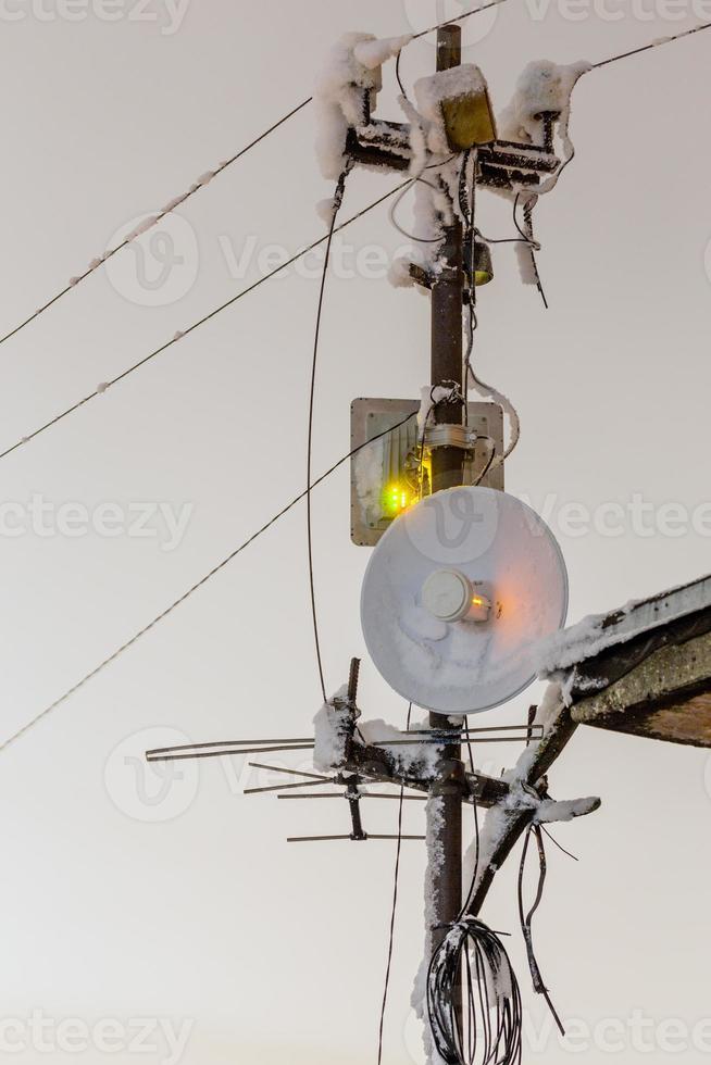 Pilar de antenas repetidoras inalámbricas congeladas de 5 ghz en la noche de invierno foto