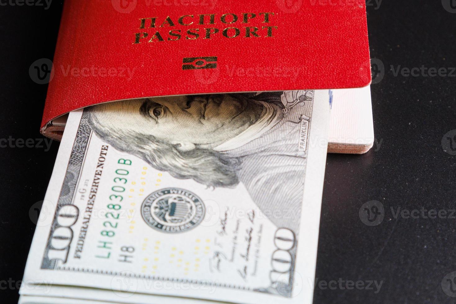 russian international passport with inserted US dollars on black background photo