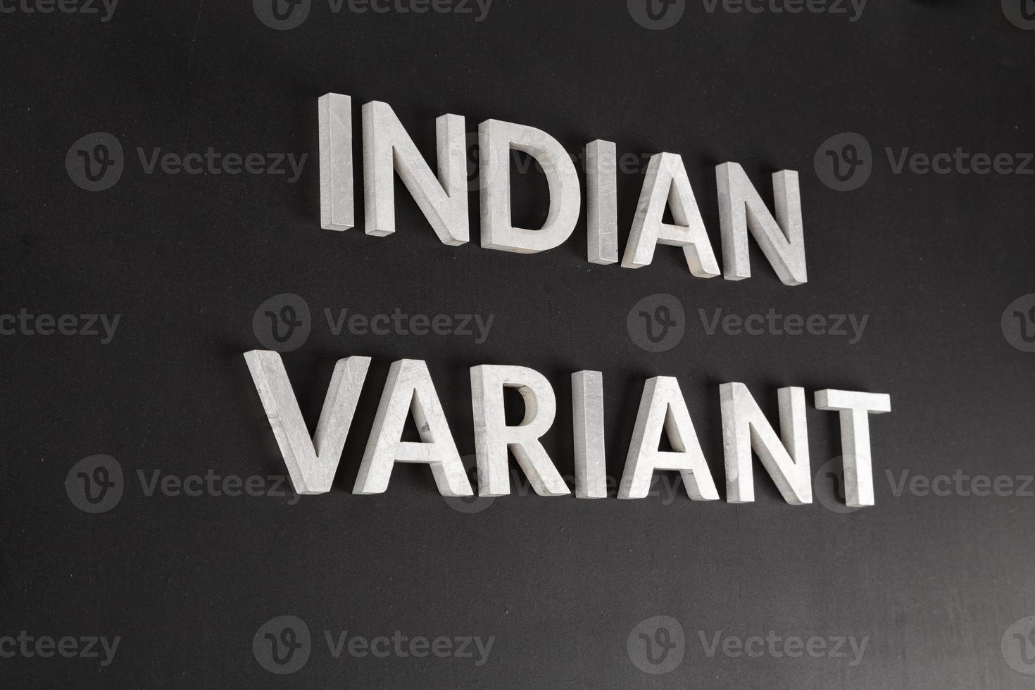 words indian variant laid with silver metal letters on flat matte black surface in tilted view photo