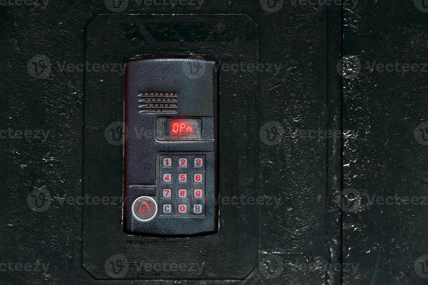 An intercom on old black painted steel surface with a keypad, digital display and rfid sensor for calling close-up photo