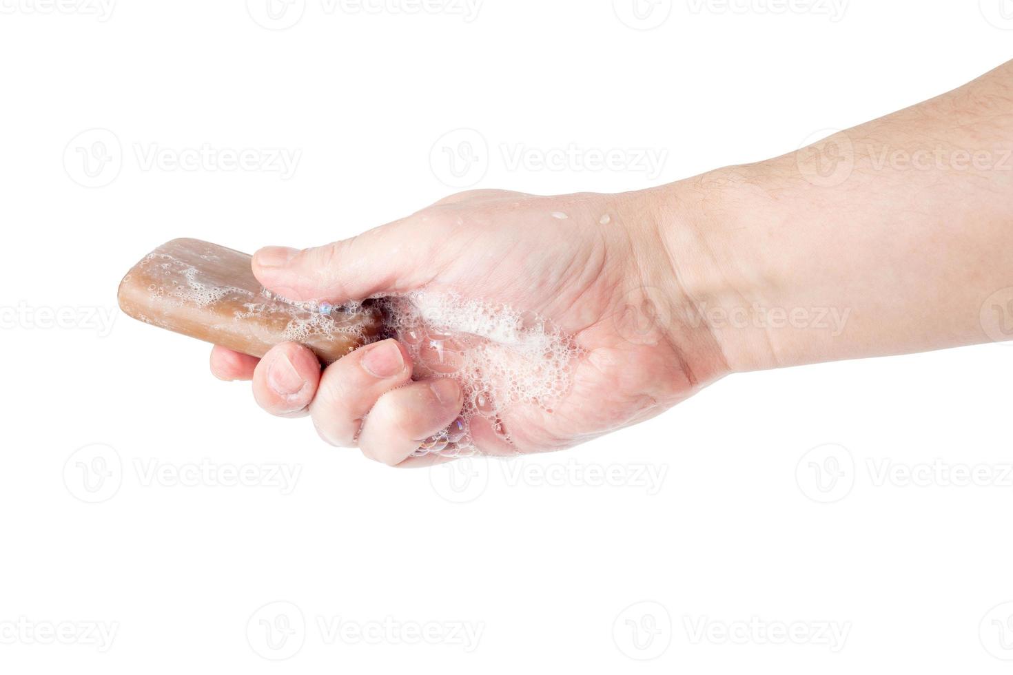 bare caucasian hand giving a wet bar of tar soap isolated on white background photo