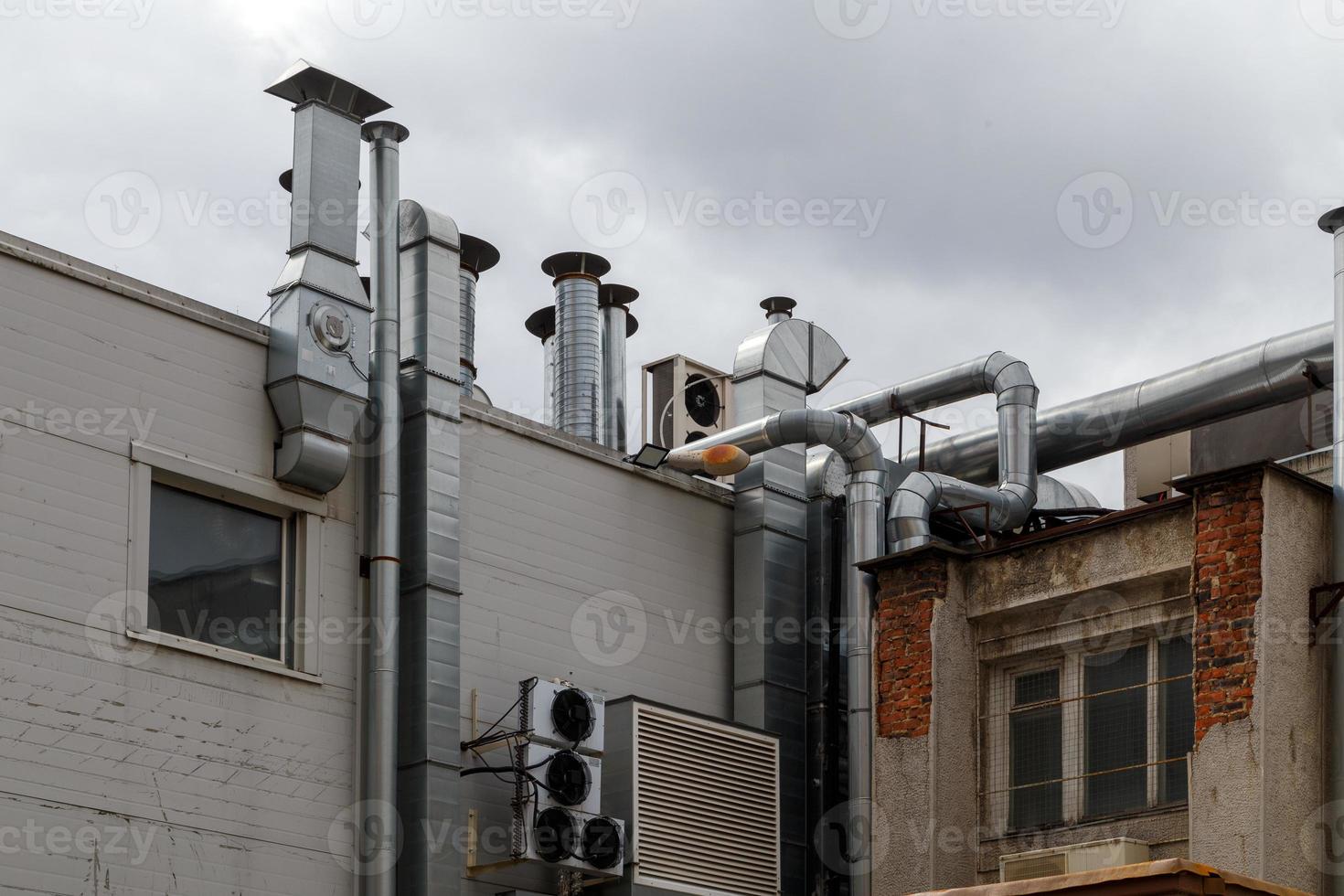 old outdoor ventilation air ducts and air conditioners outside of back wall of cafe kitchen photo