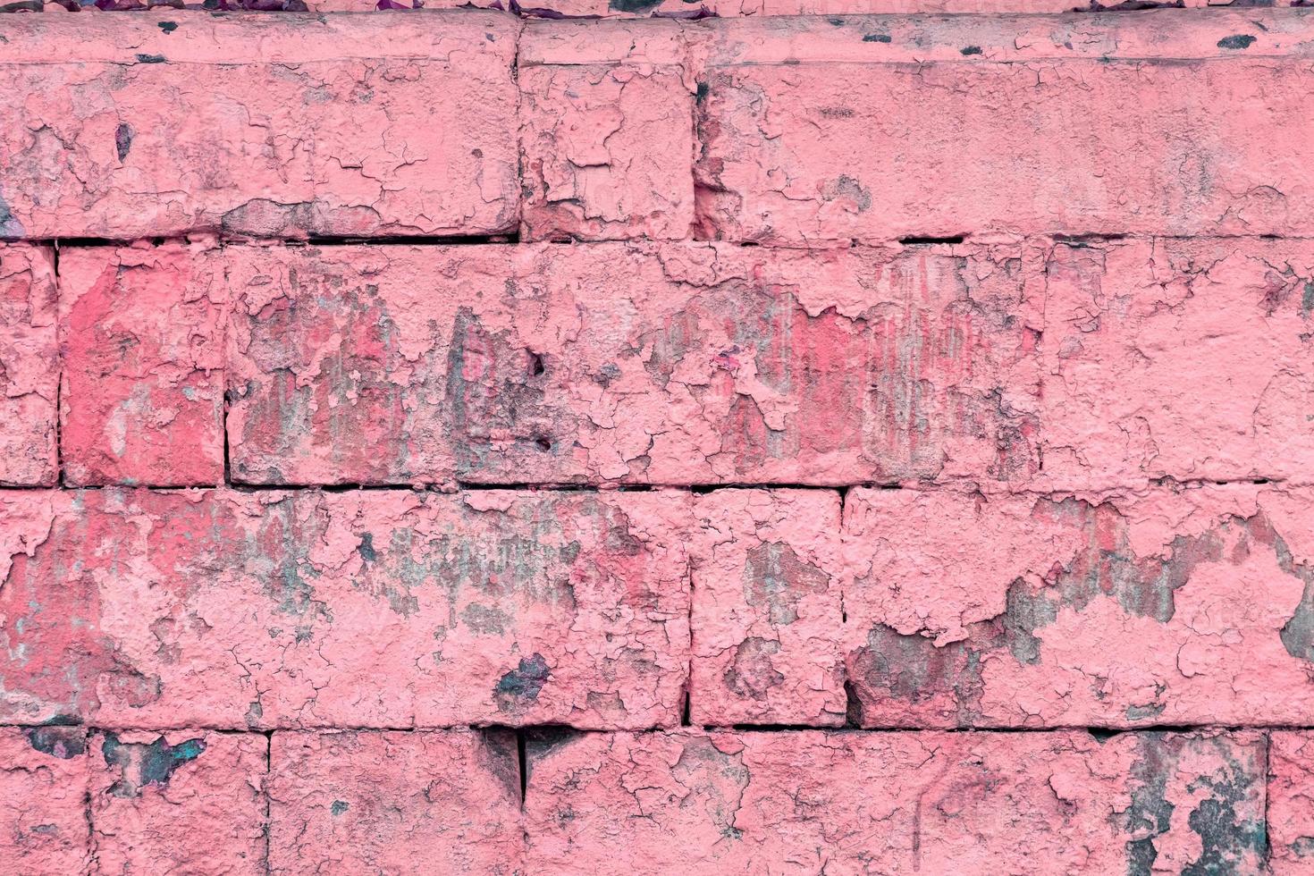 peeled off old pink paint on flat rough brick wall surface - full frame background and texture photo