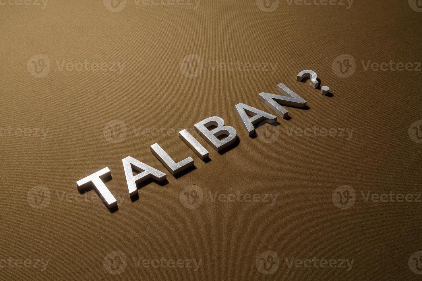 the question taliban laid with silver metal letters on rough tan khaki canvas fabric photo